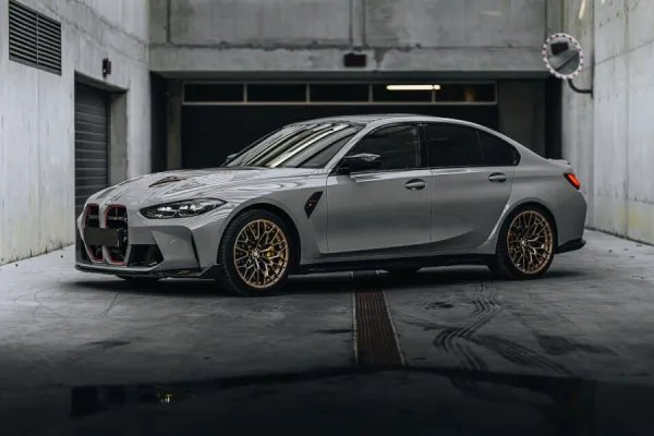 Silver BMW M3 CS G80 with gold wheels in Dubai garage, for luxury car rental with Solid Cars.