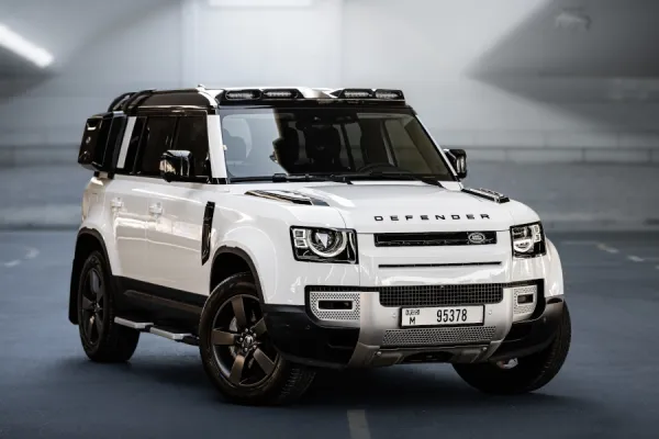 White Land Rover Defender SUV parked indoors, showcasing modern design and rugged style.