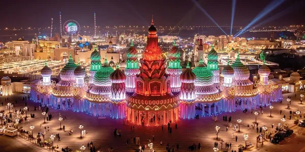 Global Village in Dubai at night with illuminated pavilions and colorful lights